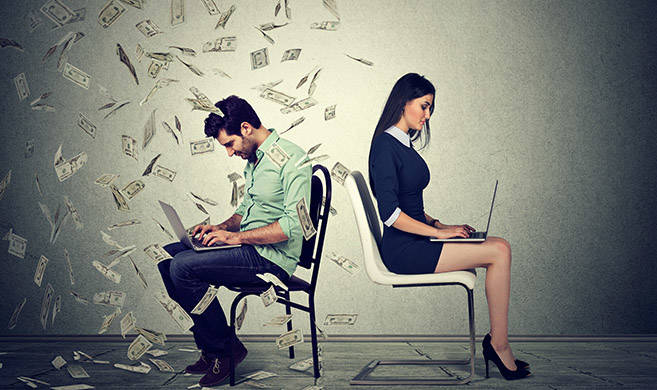 a man and a woman work on a computer, the man has money falling on him