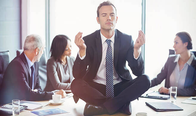 man in suit meditating in the middle of a meeting - vectorfusionart-AdobeStock