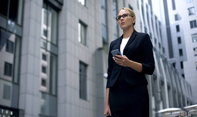 a woman in a suit looking at the horizon in the middle of buildings - cover photo