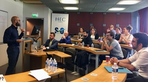 HEC Paris Professor Daniel Martinez and Dane Pflueger talking in a room to researchers