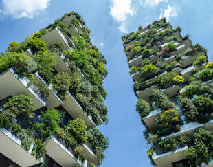 Immeubles avec des balcons remplis de plantes vertes.