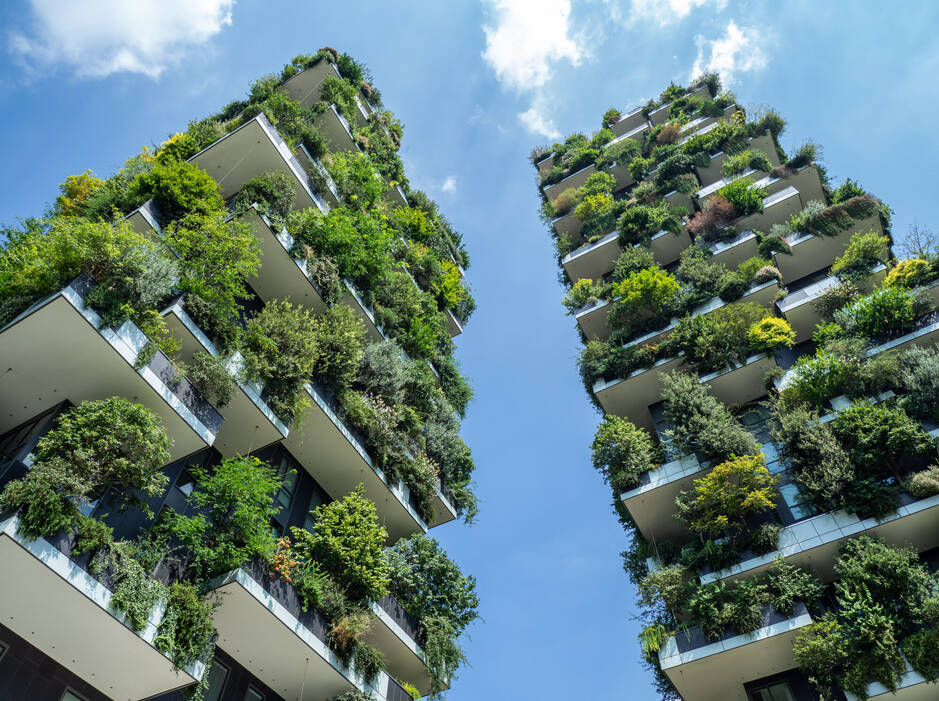 Immeubles avec des balcons remplis de plantes vertes.